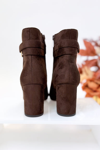 Novella- Brown Suede Buckle Booties against white studio background back view.