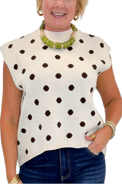 Front detail view of woman wearing Swagger Boutique’s Oatmeal &amp; Brown Polka Dot Sleeveless Sweater by Entro with jeans against white studio background.