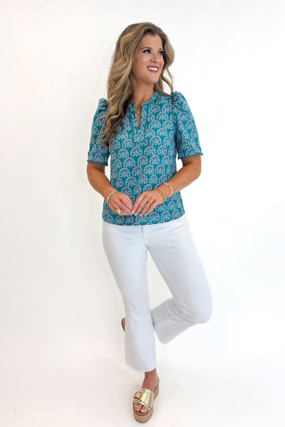Front view of woman wearing Swagger Boutique’s Ocean Sunshower Flora Adelyn Top by Mary Square with jeans against white studio background.