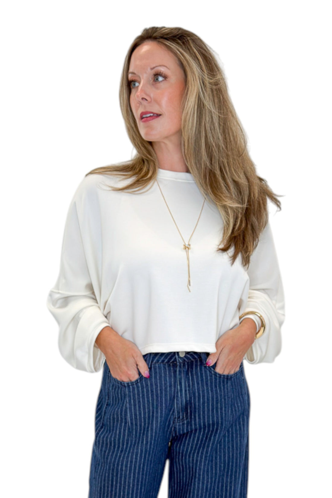 Front view of woman wearing Swagger Boutique’s Off White Cropped Sweatshirt with jeans against white studio background.