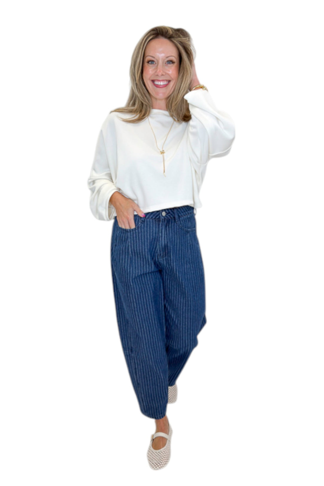 Front view of woman wearing Swagger Boutique’s Off White Cropped Sweatshirt with jeans against white studio background.