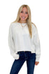 Front view of woman wearing Swagger Boutique’s Off White Ribbed Detail Sweatshirt with jeans against white studio background.
