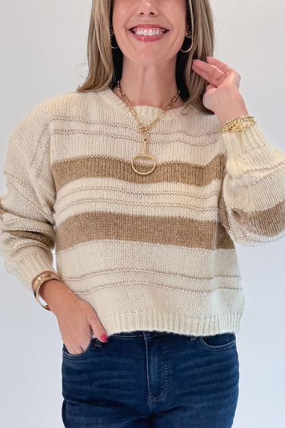 Front detail view of woman wearing Swagger Boutique’s Off White, Beige and Metallic Stripe Sweater by Molly Bracken with jeans against white studio background.
