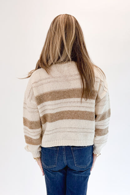 Back view of woman wearing Swagger Boutique’s Off White, Beige and Metallic Stripe Sweater by Molly Bracken with jeans against white studio background.