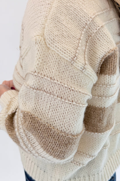 Front detail view of woman wearing Swagger Boutique’s Off White, Beige and Metallic Stripe Sweater by Molly Bracken with jeans against white studio background.