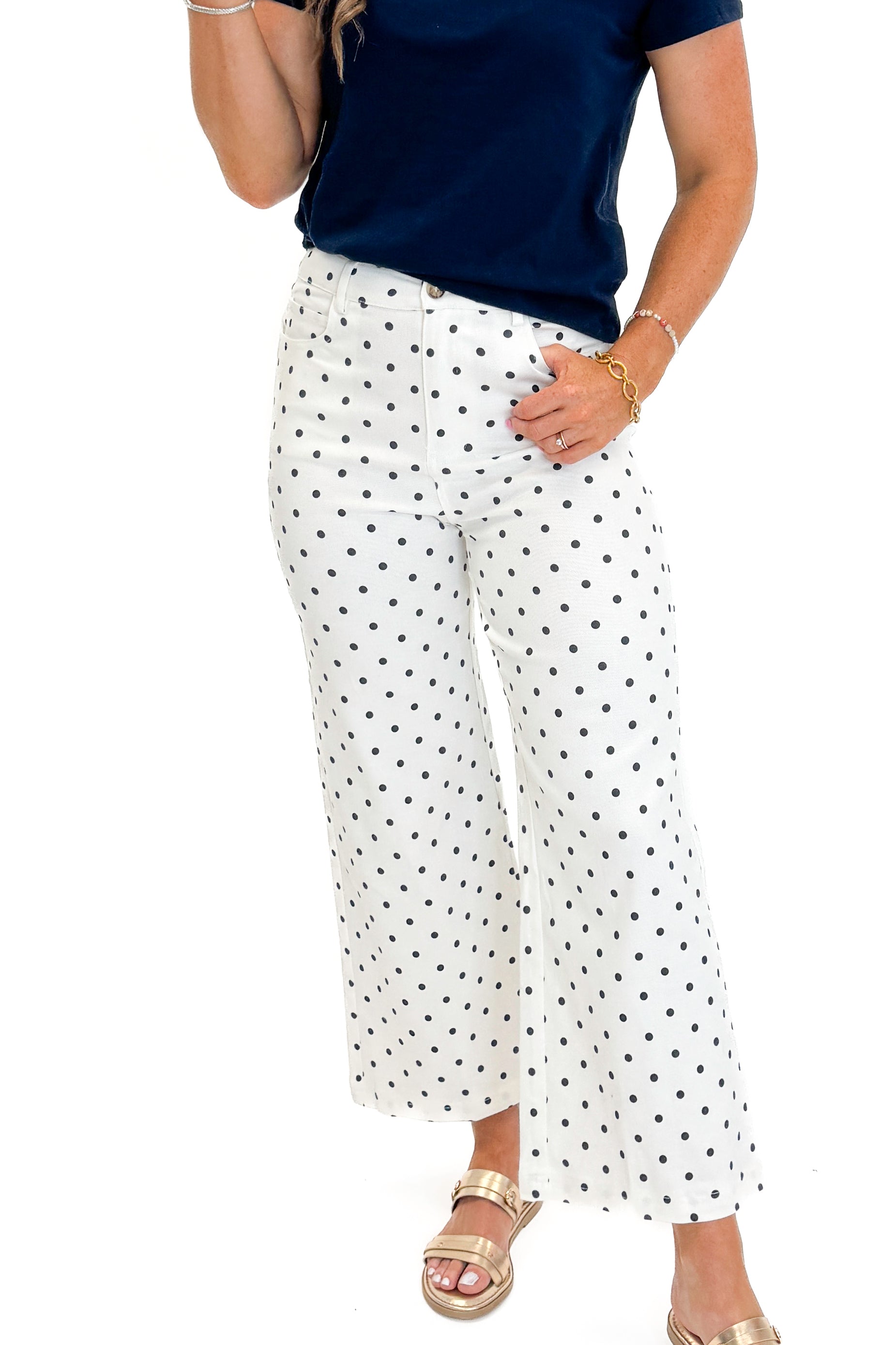 Front detail view of woman wearing Swagger Boutique’s Off White &amp; Navy Polka Dot Jeans by Entro with navy top against white studio background.