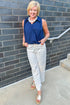 Front view of woman wearing Swagger Boutique’s Off White & Navy Polka Dot Jeans by Entro with navy top against white studio background.