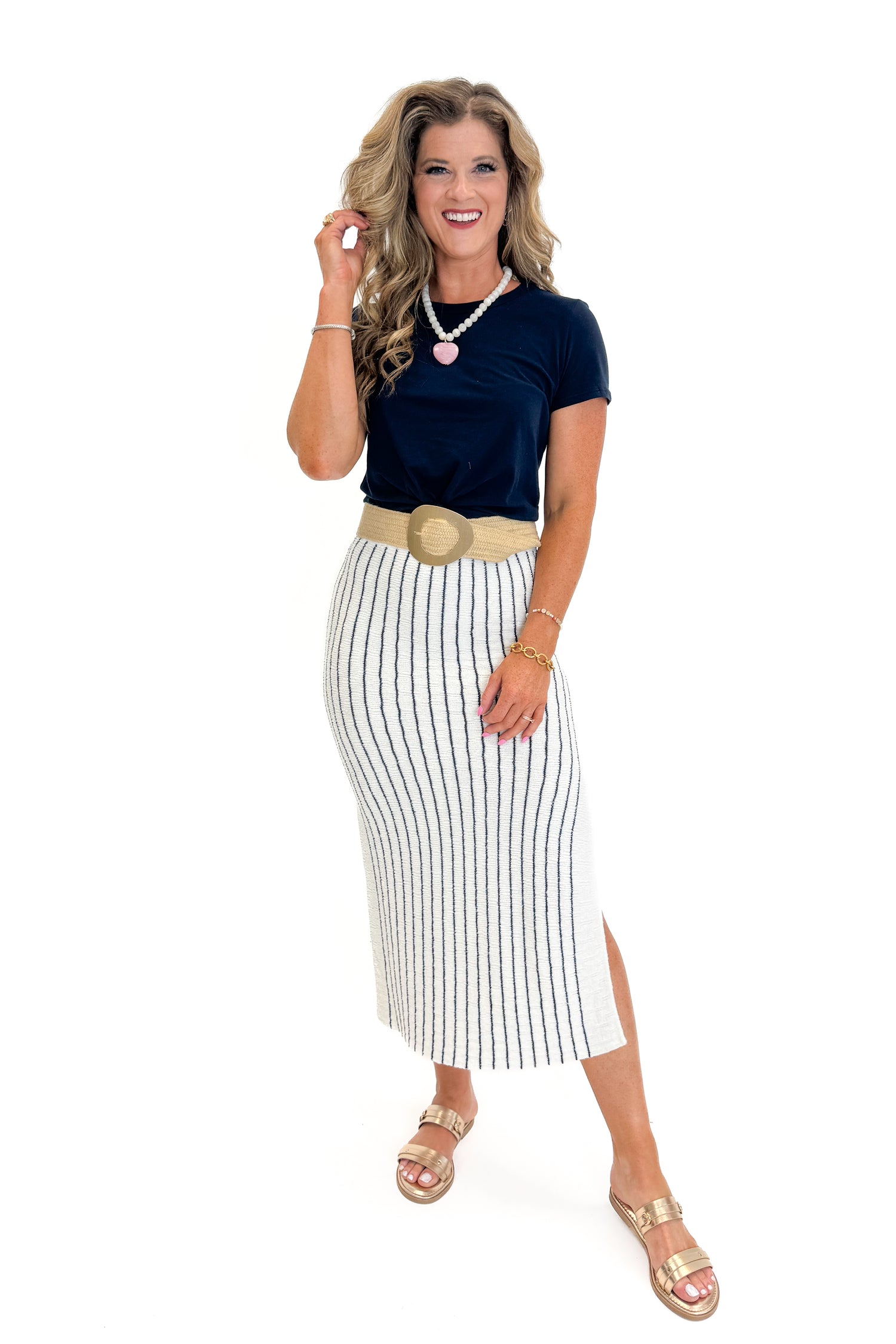 Front detail view of woman wearing Swagger Boutique’s Off White &amp; Navy Striped Midi Skirt With Slit and navy top against white studio background.