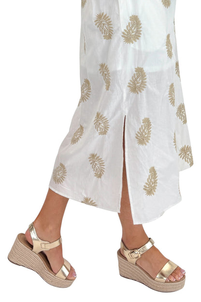 Side detail view of woman wearing Swagger Boutique’s Off White &amp; Taupe Embroidered Midi Dress with sandals against white studio background.