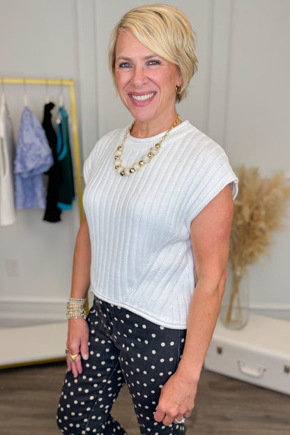front close up view of woman wearing a white short sleeve sweater top. 
