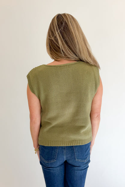 Back view of woman wearing Swagger Boutique’s Olive Open Knit Sleeveless Sweater with jeans against white studio background.