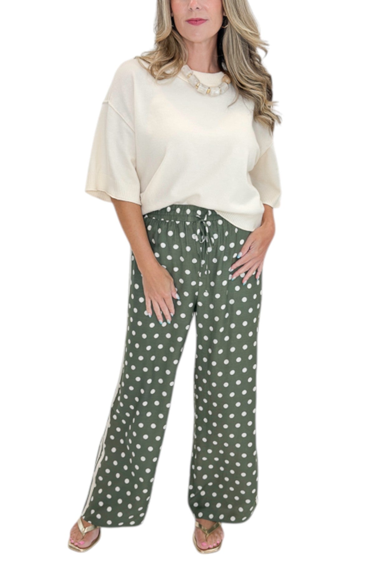 Front detail view of woman wearing Swagger Boutique’s Cream 3/4 Sleeve Lightweight Sweater by Entro with Olive Polka Dot Stripe Trim Pants by Entro against white studio background.