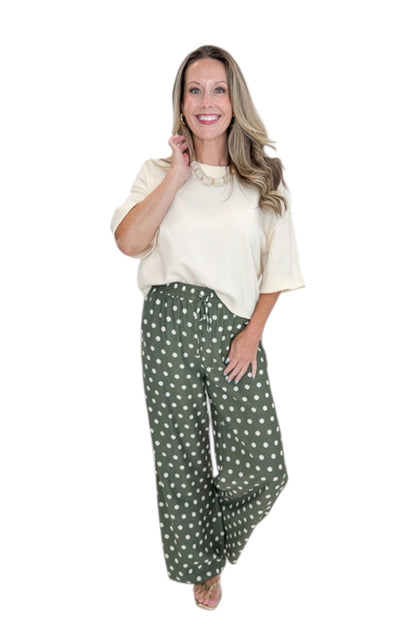 Front view of woman wearing Swagger Boutique’s Cream 3/4 Sleeve Lightweight Sweater by Entro with Olive Polka Dot Stripe Trim Pants by Entro against white studio background.