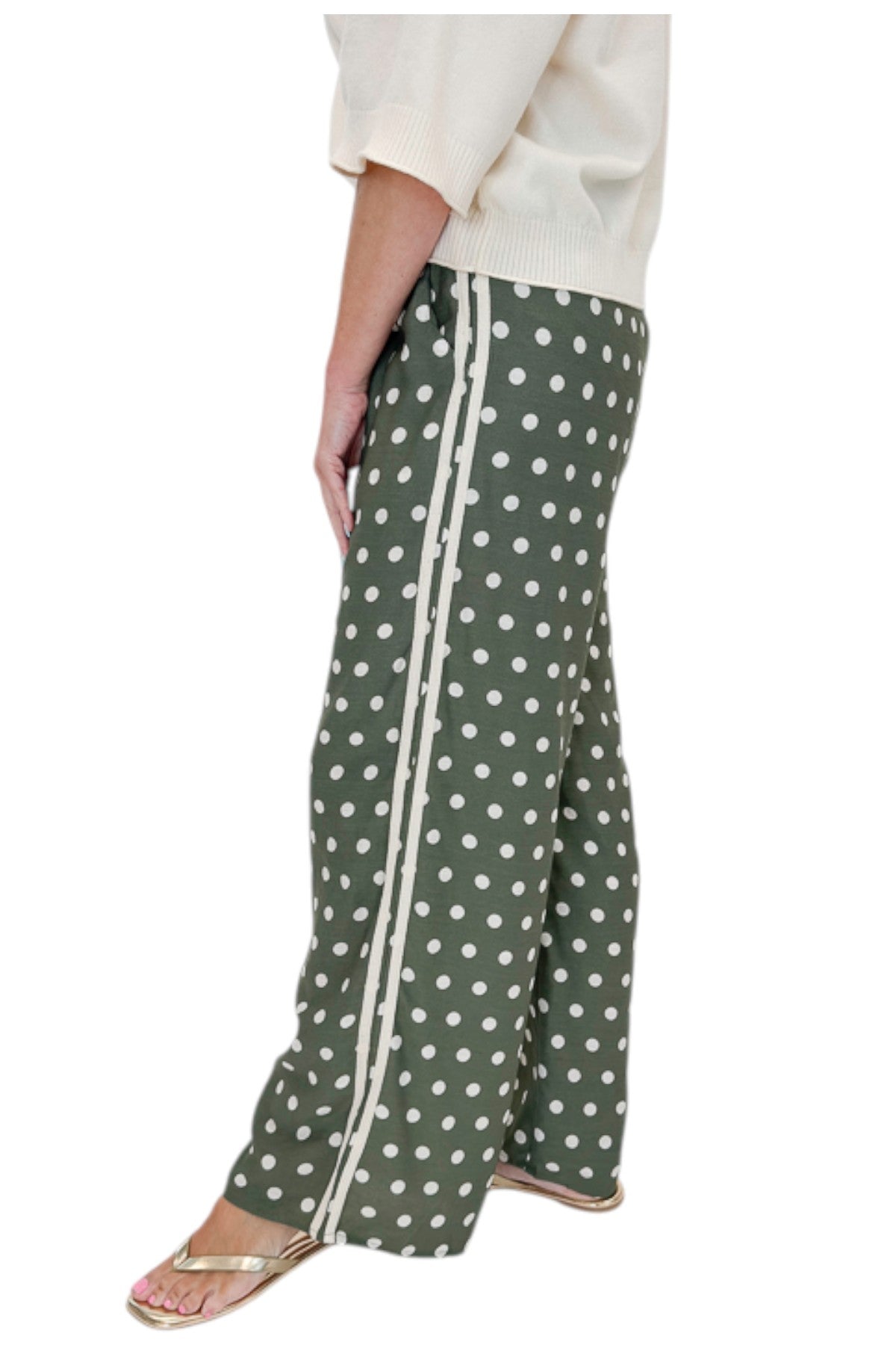 Side view of woman wearing Swagger Boutique’s Cream 3/4 Sleeve Lightweight Sweater by Entro with Olive Polka Dot Stripe Trim Pants by Entro against white studio background.