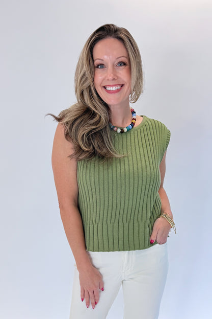 Front view of woman wearing Swagger Boutique’s Olive Ribbed Sleeveless Sweater with jeans against white studio background.