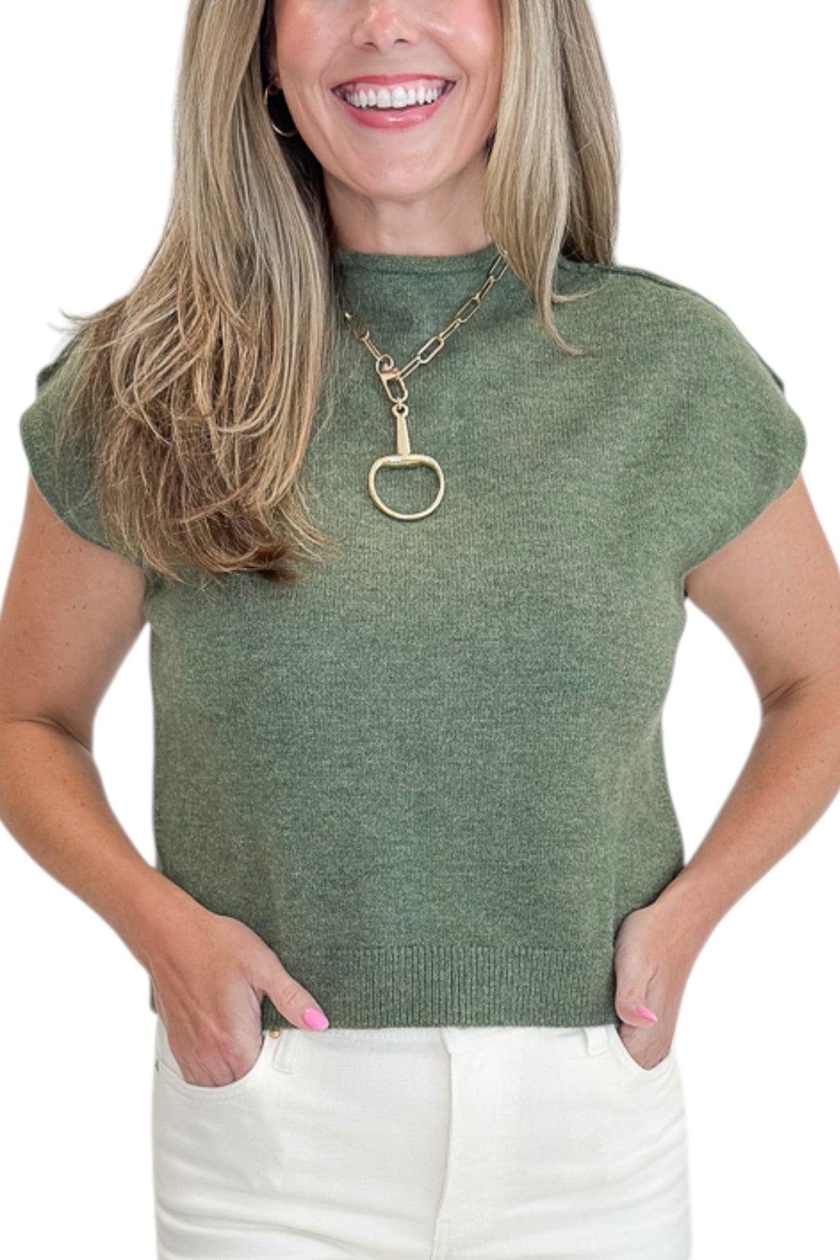 Front detail view of woman wearing Swagger Boutique’s Olive Sleeveless Sweater by Entro with jeans against white studio background.