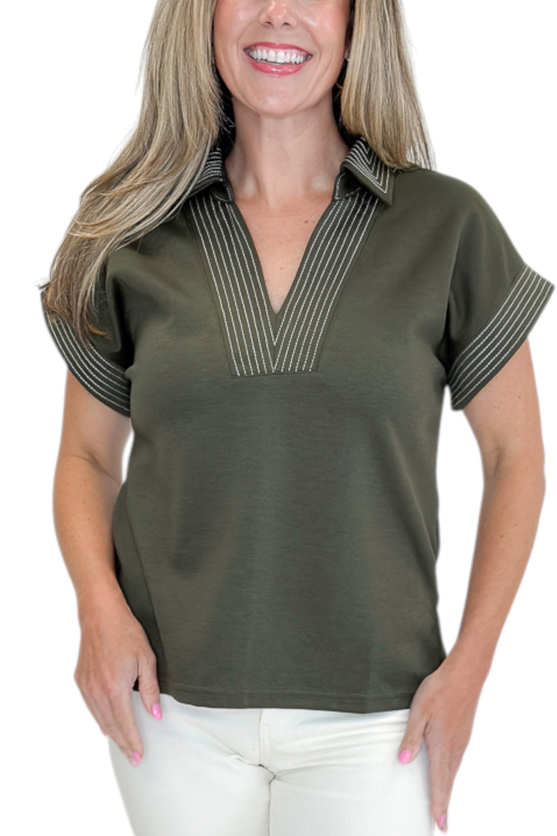 Front detail view of woman wearing Swagger Boutique’s Olive Stitched Short Sleeve Top by Entro with jeans against white studio background.