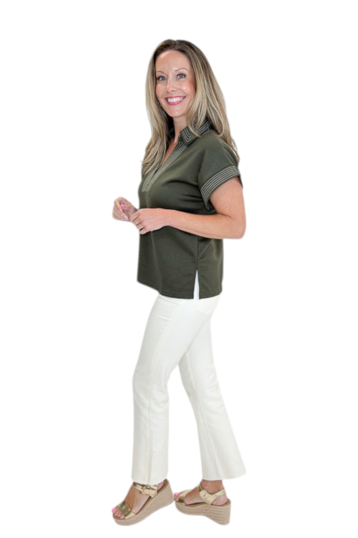 Side view of woman wearing Swagger Boutique’s Olive Stitched Short Sleeve Top by Entro with jeans against white studio background.