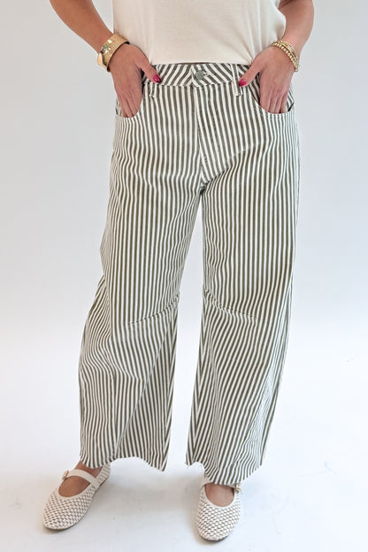 Front view of woman wearing Swagger Boutique’s top with Olive Striped Barrel Jeans by Just Black Denim against white studio background.