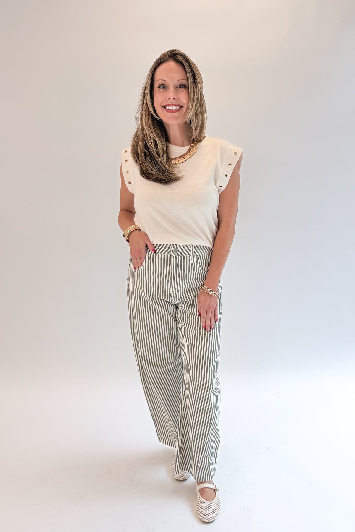 Front view of woman wearing Swagger Boutique’s top with Olive Striped Barrel Jeans by Just Black Denim against white studio background.