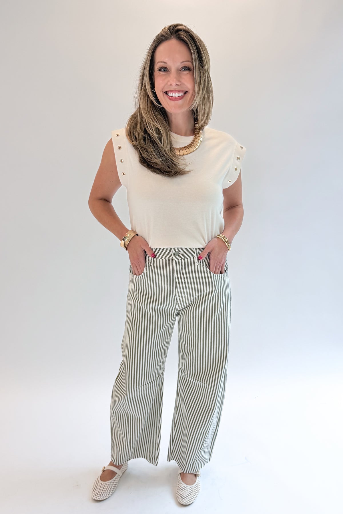 Front view of woman wearing Swagger Boutique’s top with Olive Striped Barrel Jeans by Just Black Denim against white studio background.