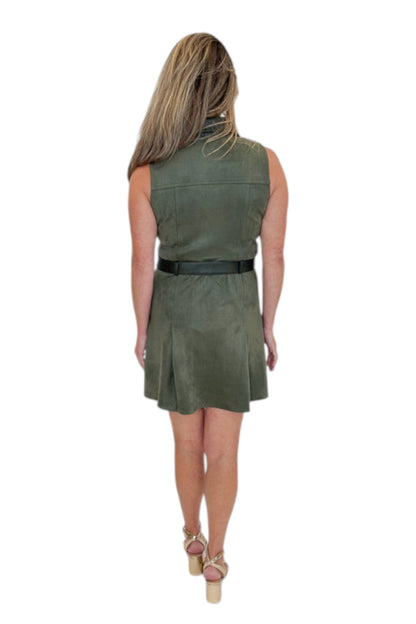 Back view of woman wearing Swagger Boutique’s Olive Suede Mini Dress with heels against white studio background.