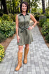 Front view of woman wearing Swagger Boutique’s Olive Suede Mini Dress with boots walking down a path outside.