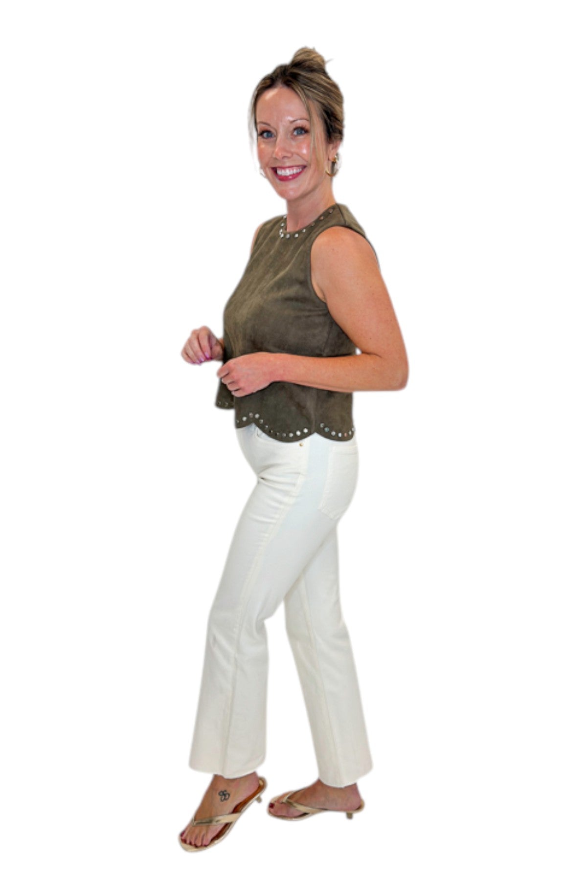 Side view of woman wearing Swagger Boutique’s Olive Suede Stud Tank with Kelsey Ecru Jeans against white studio background.