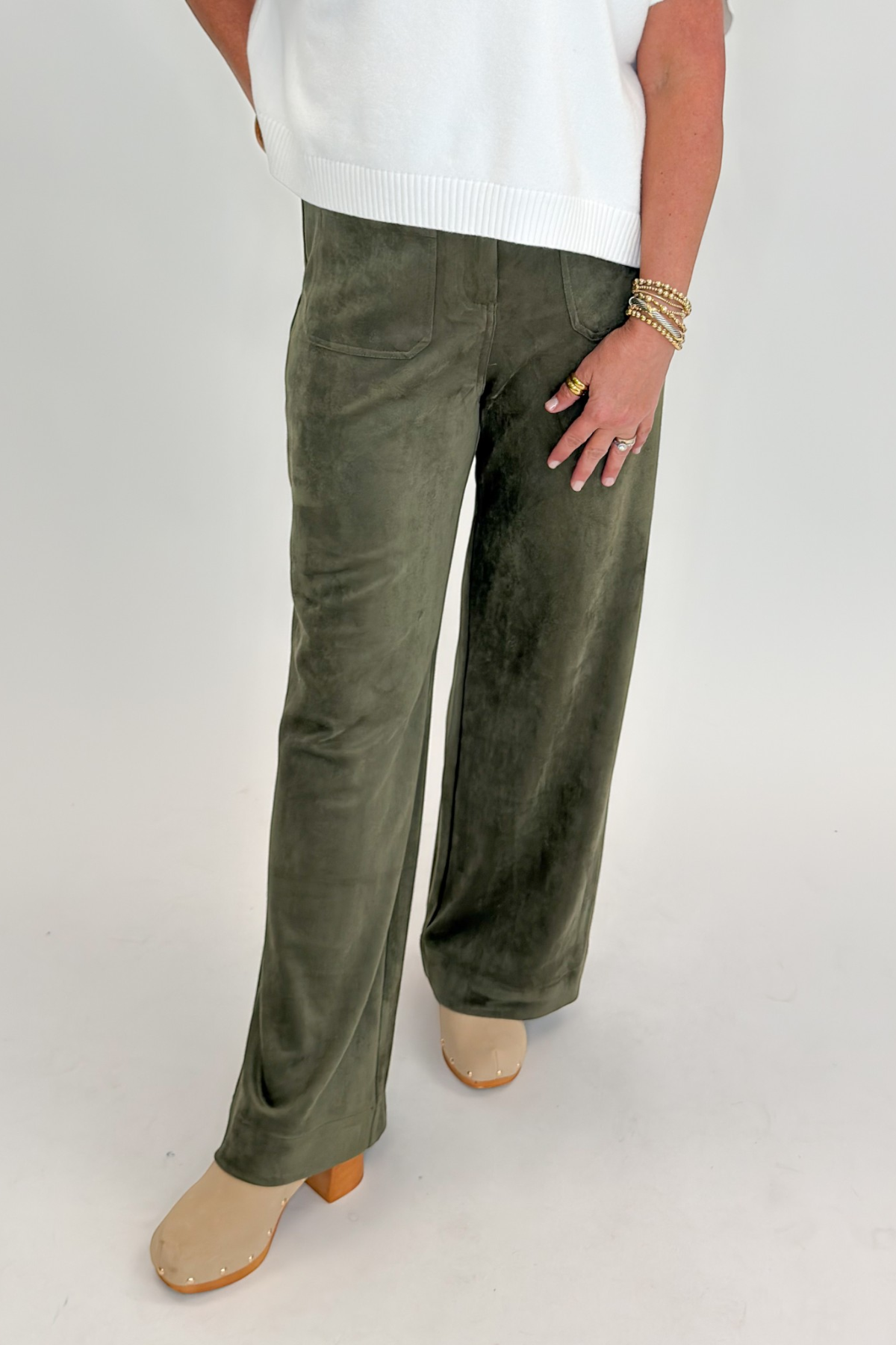 Front view of woman wearing Swagger Boutique’s sweater with Olive Suede Wide Leg Pants against white studio background.