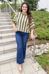 Front view of woman wearing Swagger Boutique’s Olive & Cream Striped Short Sleeve Sweater by Entro with jeans walking outside down a path.