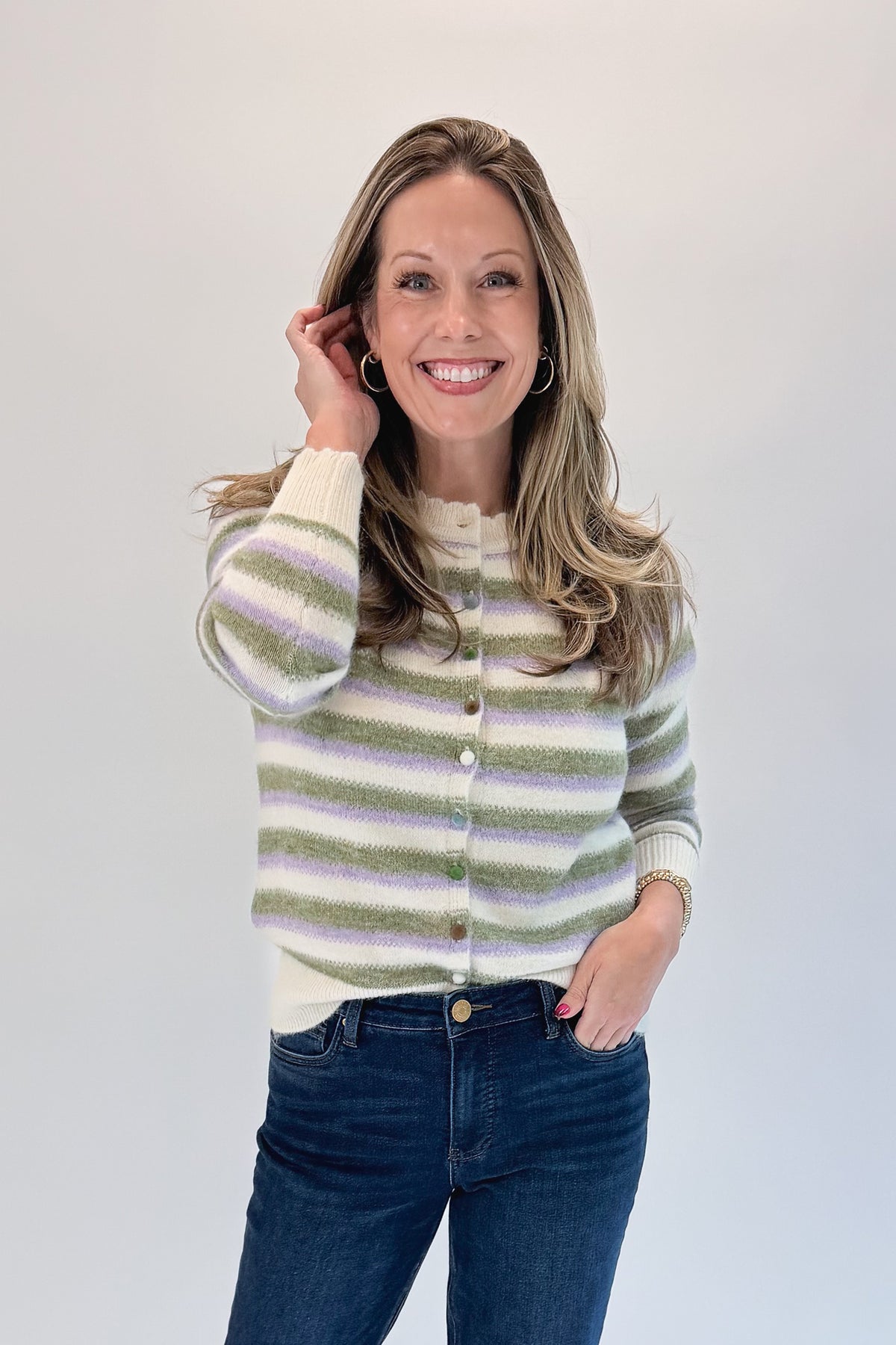 Front view of woman wearing Swagger Boutique’s Olive &amp; Lavendar Striped Button Up Cardigan with jeans against white studio background.