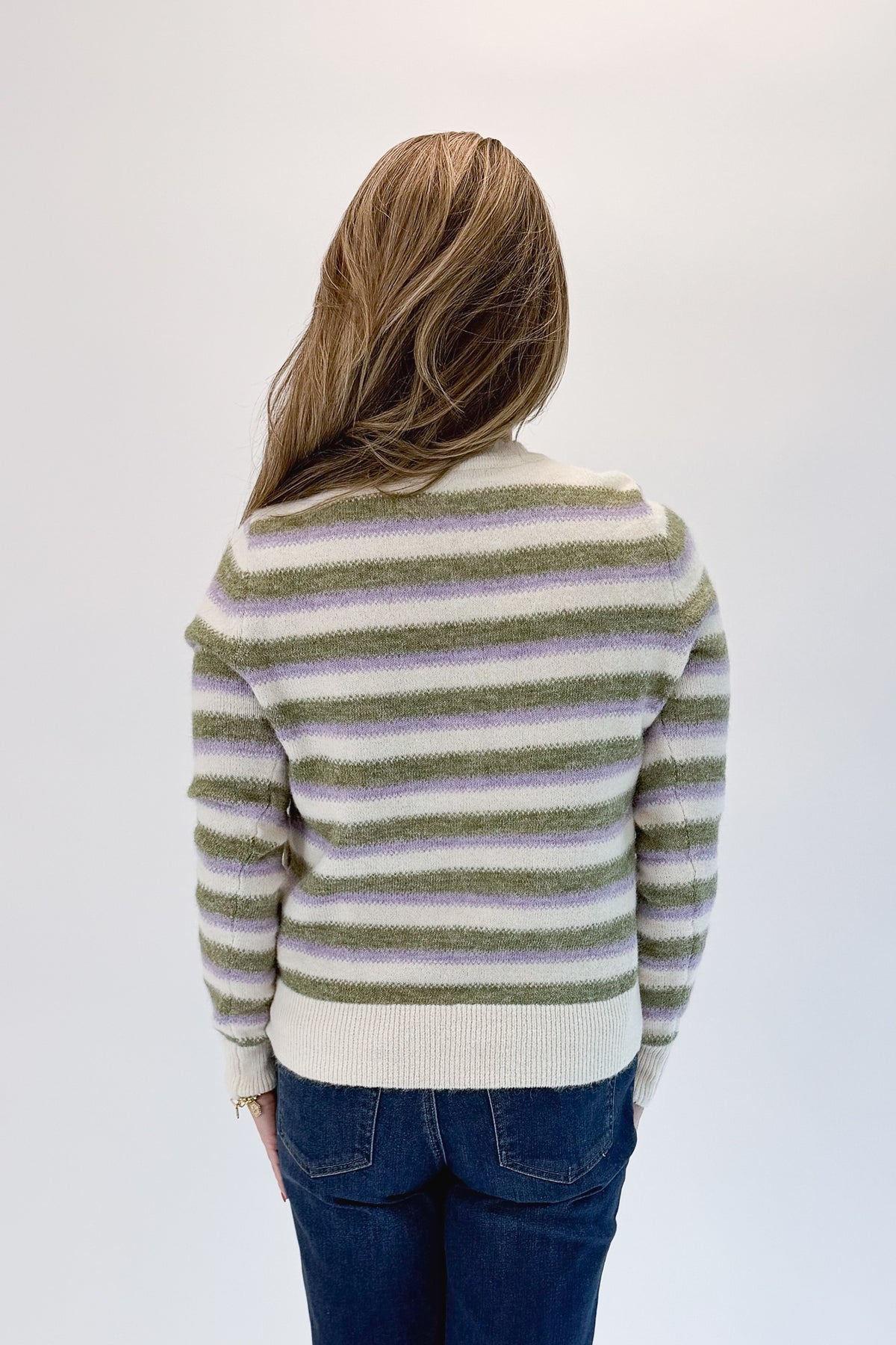 Back view of woman wearing Swagger Boutique’s Olive &amp; Lavendar Striped Button Up Cardigan with jeans against white studio background.