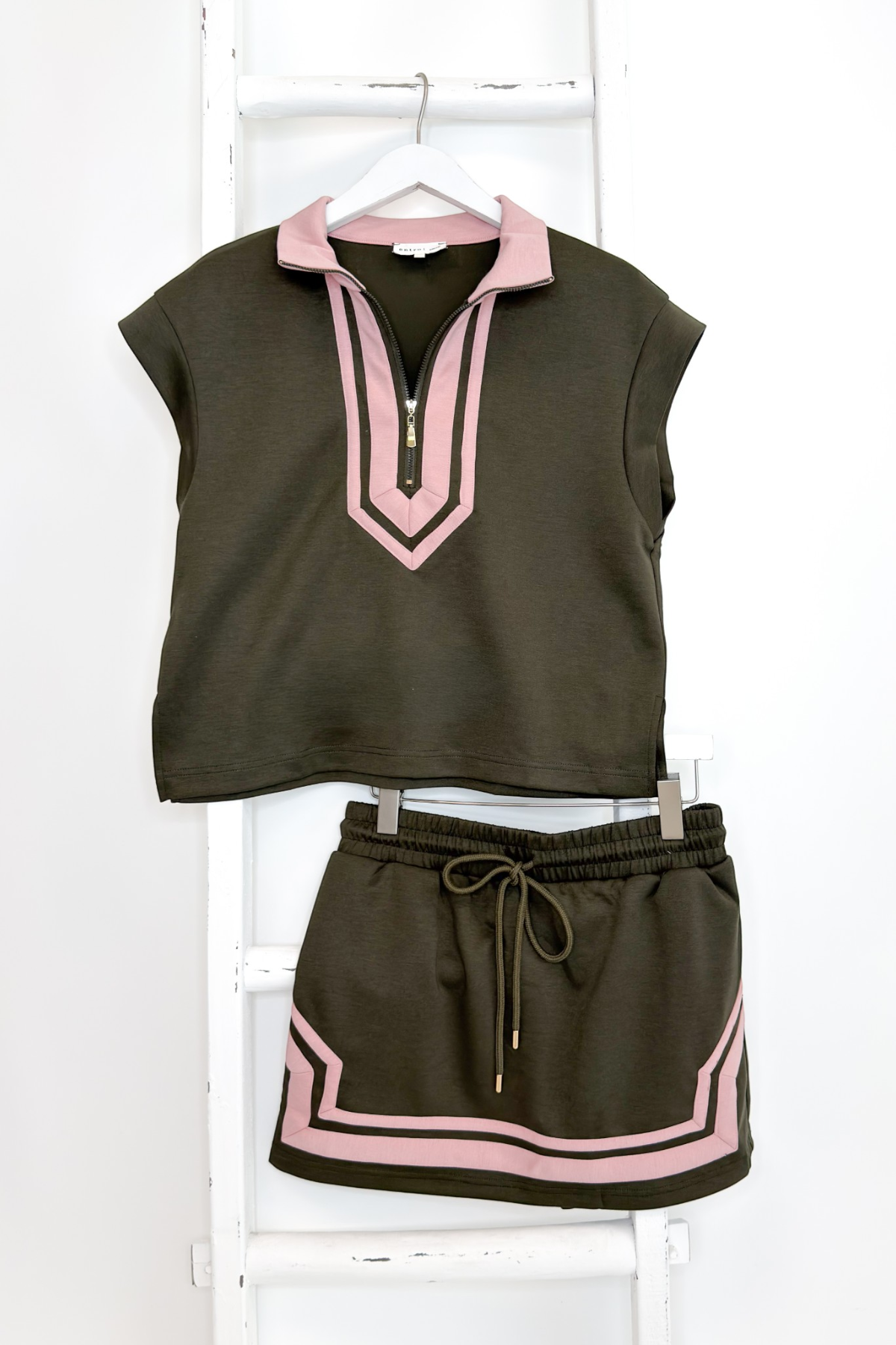 Swagger Boutique’s Olive &amp; Pink Skirt &amp; Matching Top by Entro hanging against white studio background.