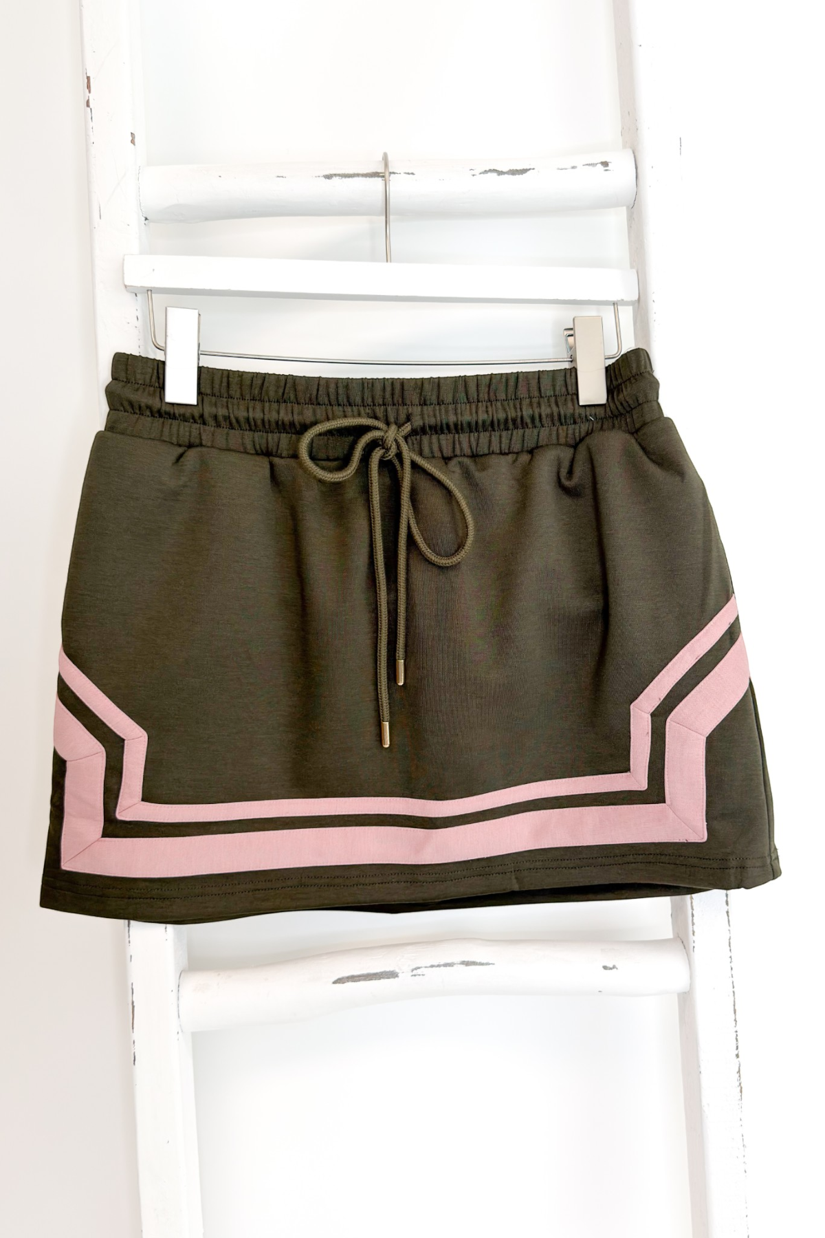 Swagger Boutique’s Olive &amp; Pink Skirt by Entro hanging against white studio background.