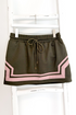 Swagger Boutique’s Olive & Pink Skirt by Entro hanging against white studio background.