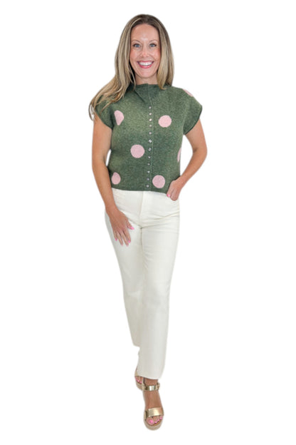 Front view of woman wearing Swagger Boutique’s Olive &amp; Pink Polka Dot Sleeveless Button Up Sweater by Entro with jeans against white studio background.