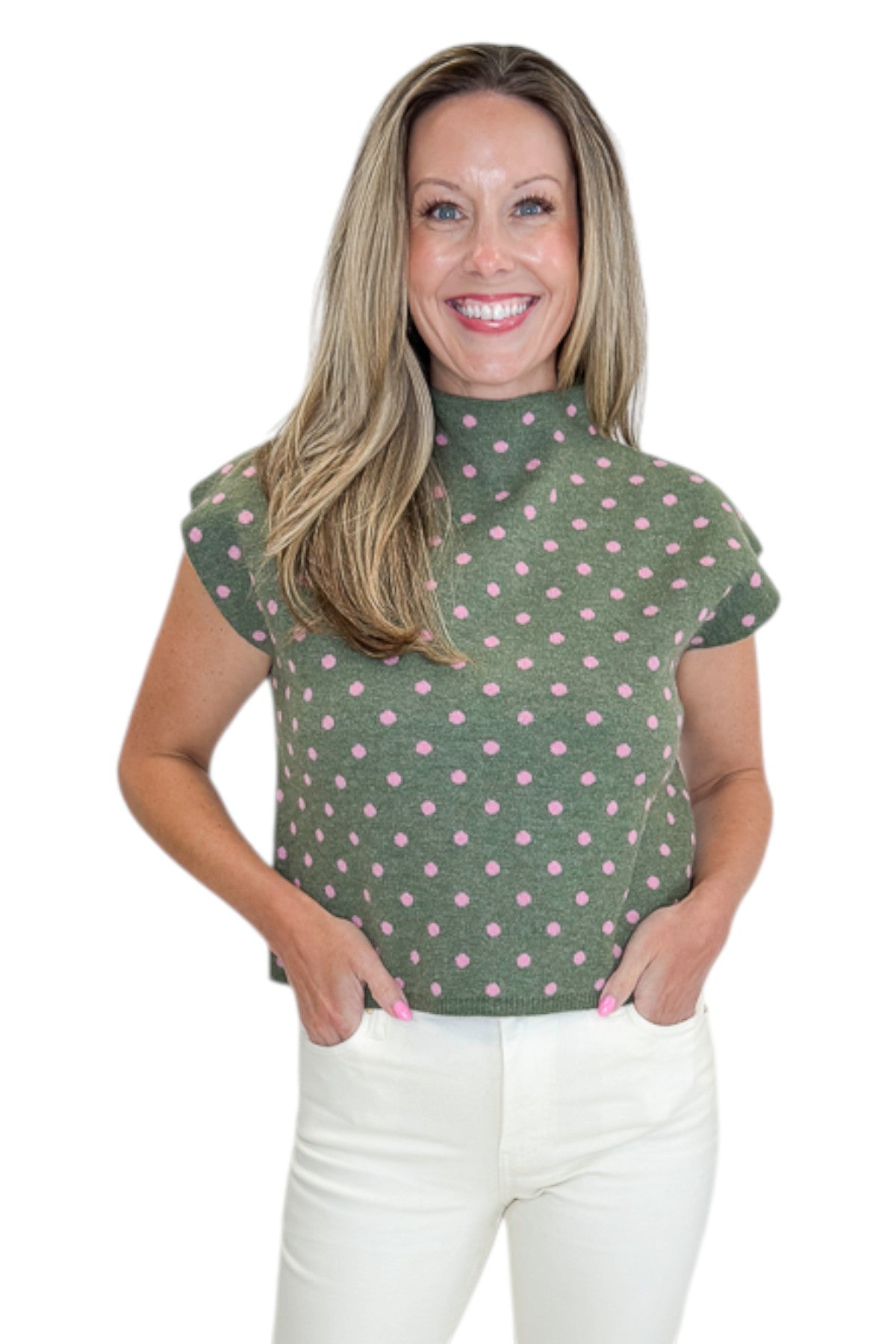 Front view of woman wearing Swagger Boutique’s Olive &amp; Pink Polka Dot Sleeveless Sweater by Entro with jeans against white studio background.