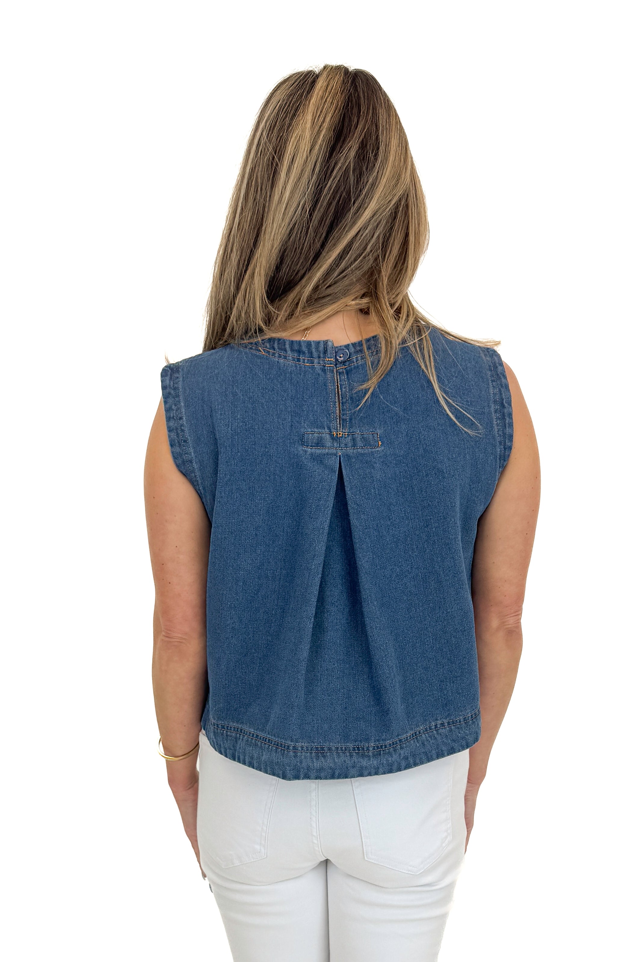 Back view of woman wearing Medium Wash Denim Top with jeans against white studio background.