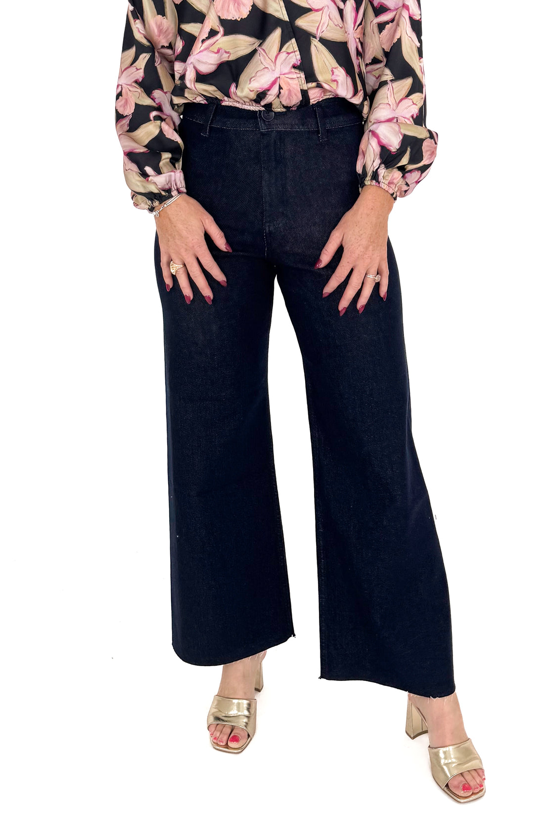 Front view of woman in a studio wearing Dark Indigo Wide Leg Jeans and print top with a white background. 