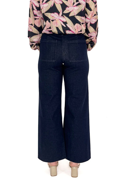 Back view of woman in a studio wearing Dark Indigo Wide Leg Jeans and print top with a white background. 