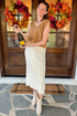 Woman holding champagne bottle in Cream Eyelash Midi Skirt and camel color sleeveless sweater. 