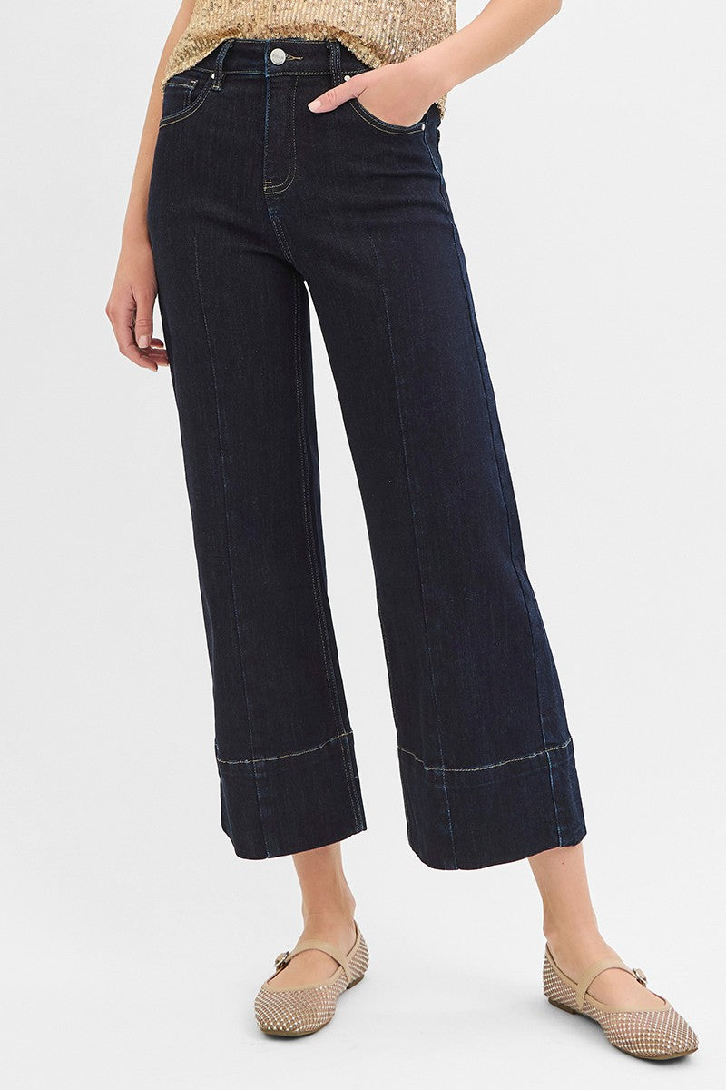 Person wearing dark blue jeans on a white background