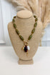 front view of olive necklace with pearl, plum, and gold accent charms on bust