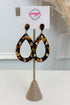 Tortoiseshell teardrop dangle earrings with gold-tone studs, displayed on a burlap-covered stand with a white card labeled &