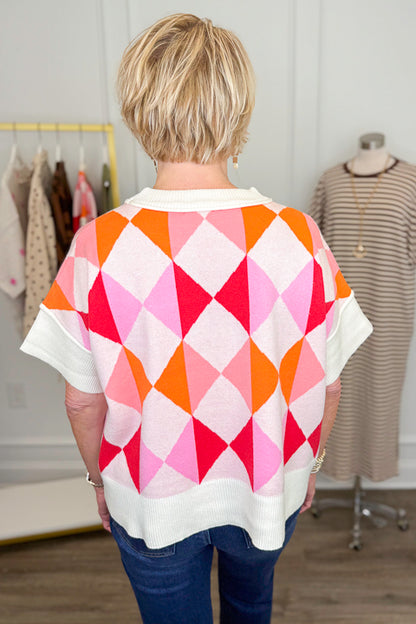 Back view of woman wearing Swagger Boutique’s Pink Color Block Short Sleeve Sweater with jeans with clothing hanging in the background.