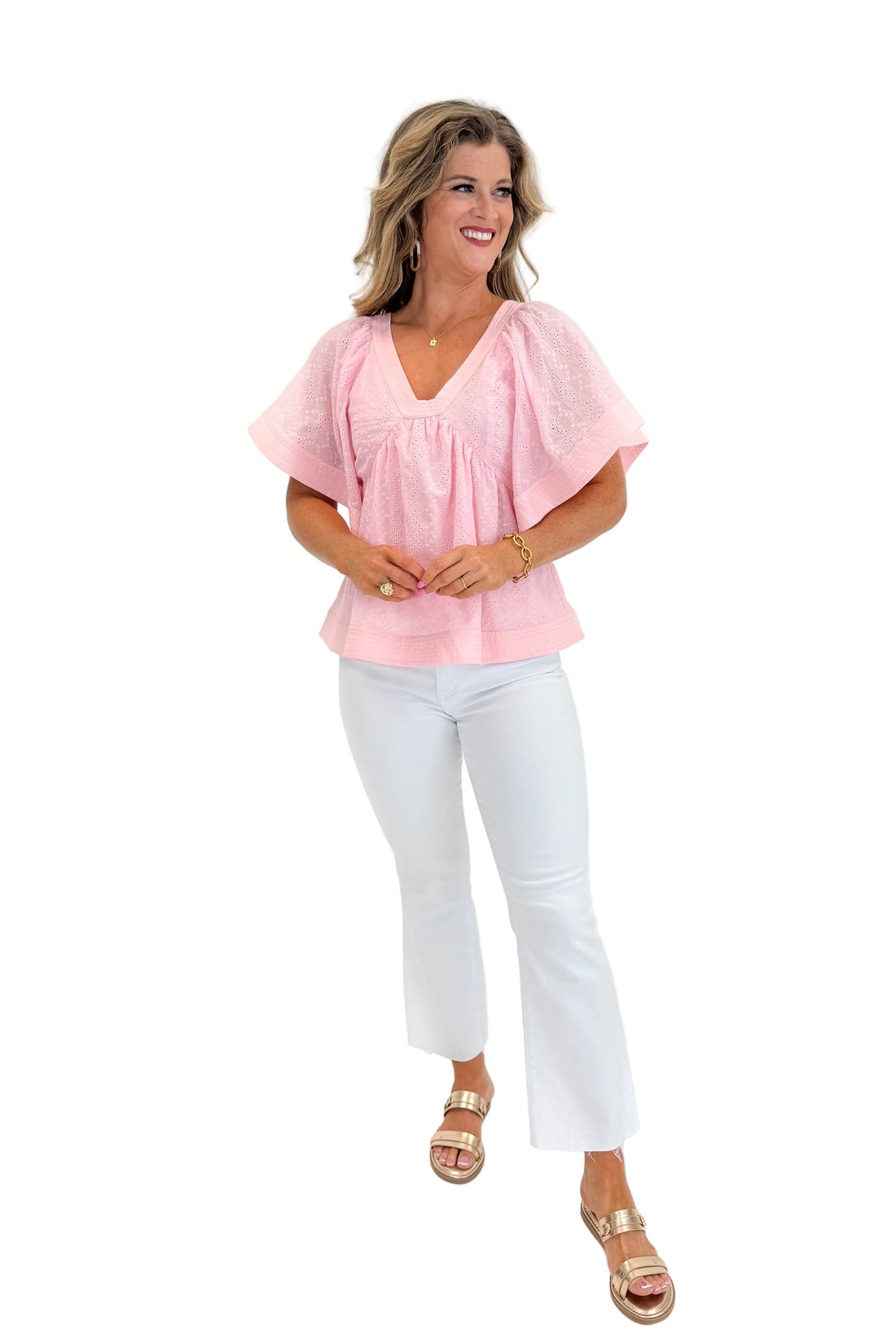 Front view of woman wearing Swagger Boutique’s Pink Eyelet V-Neck Top with jeans against white studio background.