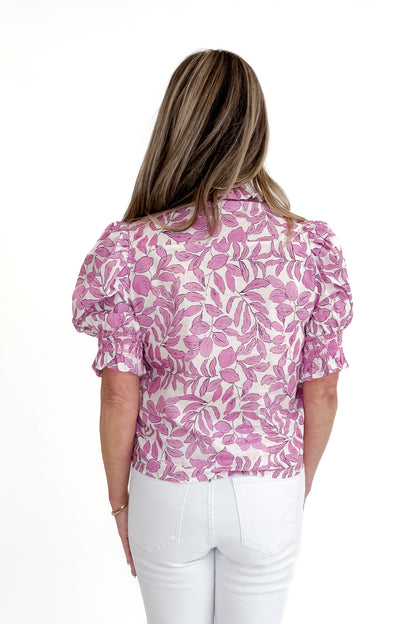 Back view of woman wearing Pink Floral Button Up Top with jeans against white studio background.