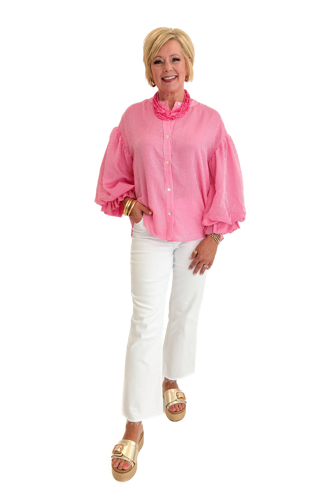 Front view of woman wearing Swagger Boutique’s Pink Pinstripe Bubble Sleeve Top with jeans against white studio background.