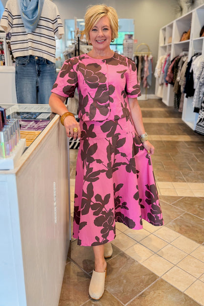 Front view of woman wearing Swagger Boutique’s Pink &amp; Brown Floral Midi Skirt &amp; Pink &amp; Brown Floral Button Up Top by Entro standing at the store.