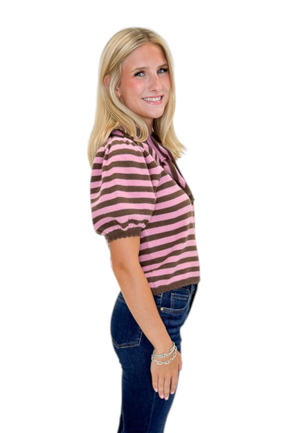 Side view of woman wearing Swagger Boutique’s Pink &amp; Brown Striped Faux Tie Short Sleeve Sweater by Entro with jeans against white studio background.